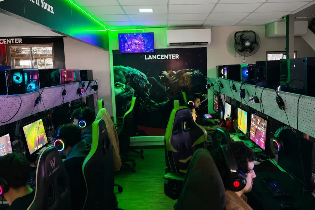 Zona General de LanCenter: dos filas de PC Gamer con iluminación RGB, sillas gamer y jugadores frente a sus monitores